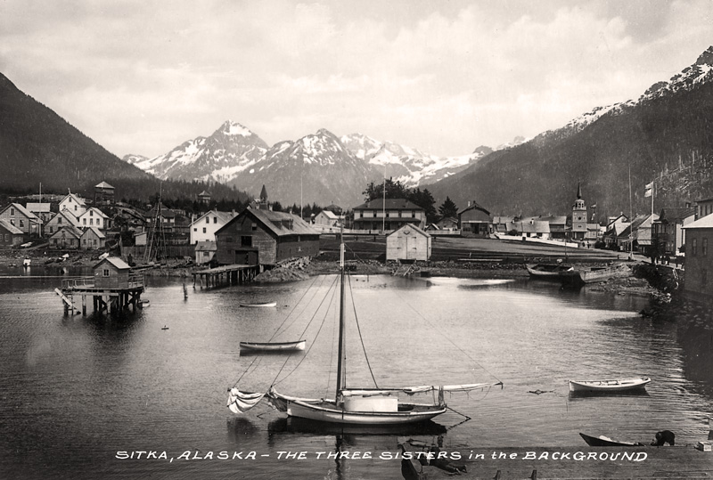 A historic photo of Sitka, Alaska with the Three Sisters in the background